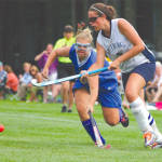 CHARGE TO THE NET â€” Lake Region defender Kayla Reinhard (left) attempts to knock the ball away from Fryeburg Academyâ€™s Ellie Jones during last Thursdayâ€™s season opener. The Raider offense was in high gear, taking a 5-1 decision. (Rivet Photo)